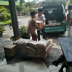 Staf NU-Care Lazisnu Ponorogo dibantu santri LKSA Al-Bhkhori tengah menurunkan paket sembako dari mobil (1511)