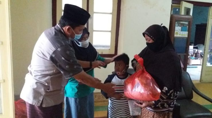 Seorang anak yatim dielus kepalanya oleh salah seorang donatur saat menerima santunan