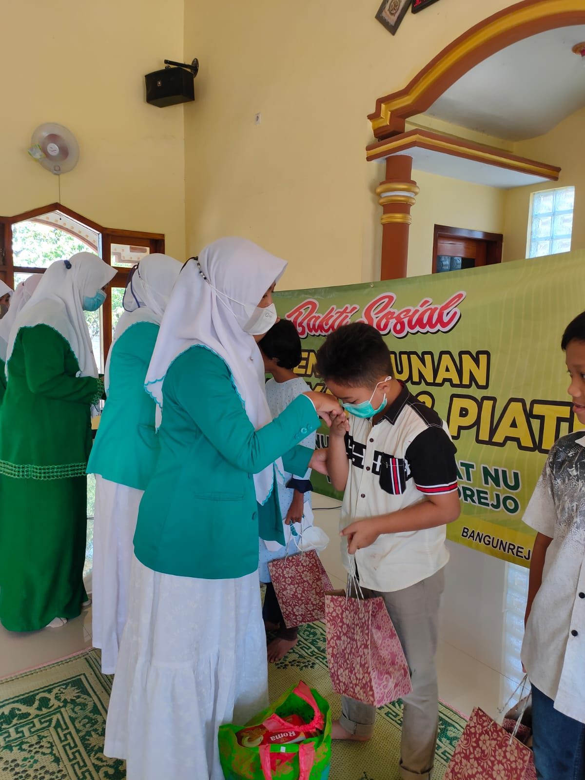 Seorang anak-yatim menerima paket santunan yang dihimpun PR Fatayat dan Muslimat NU Bangunrejo, Sukorejo