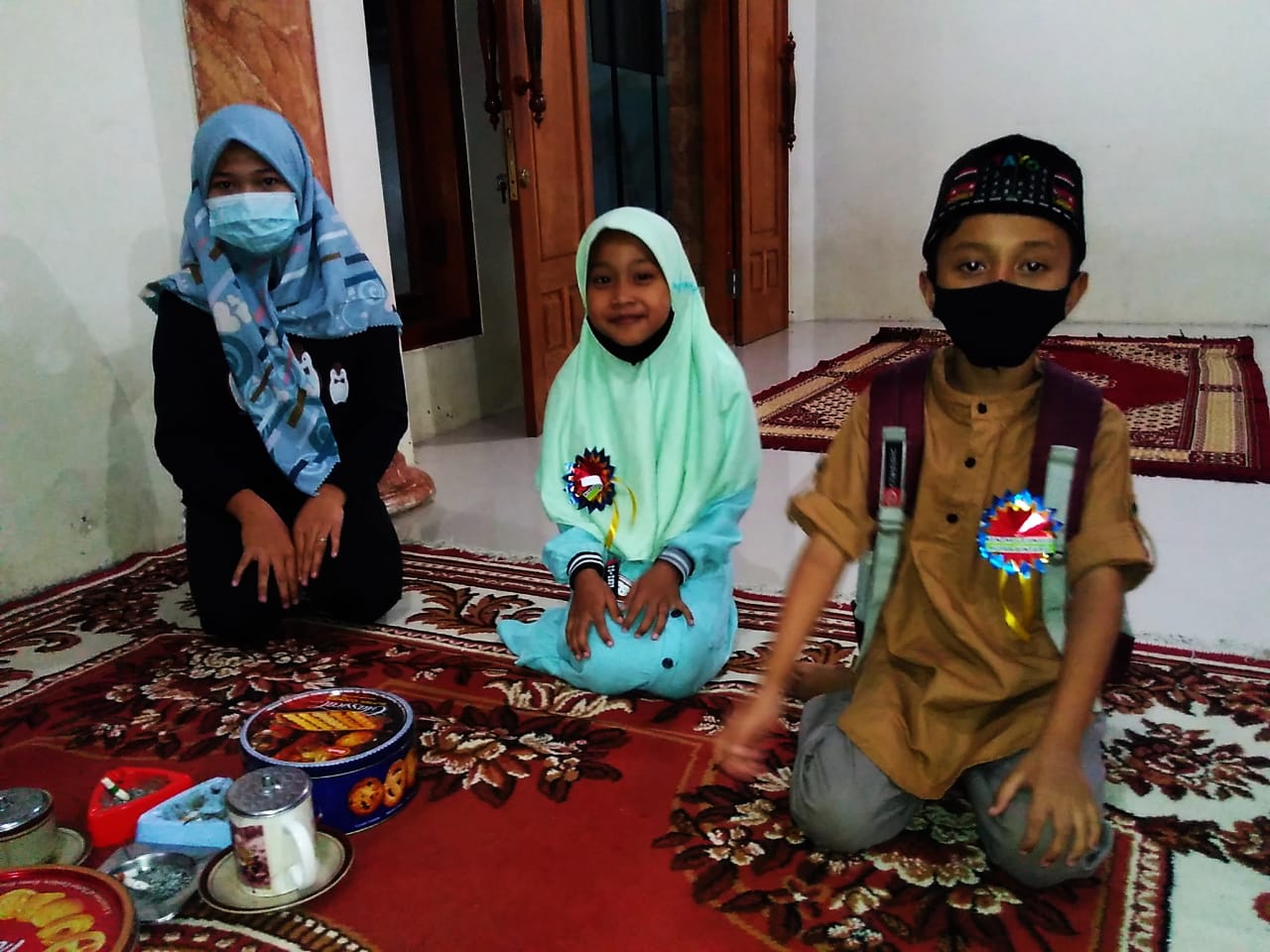 Tiga anak yatim menunjukkan wajah ceria seusai menerima santunan LKKNU dan PP Nurul Qur'an